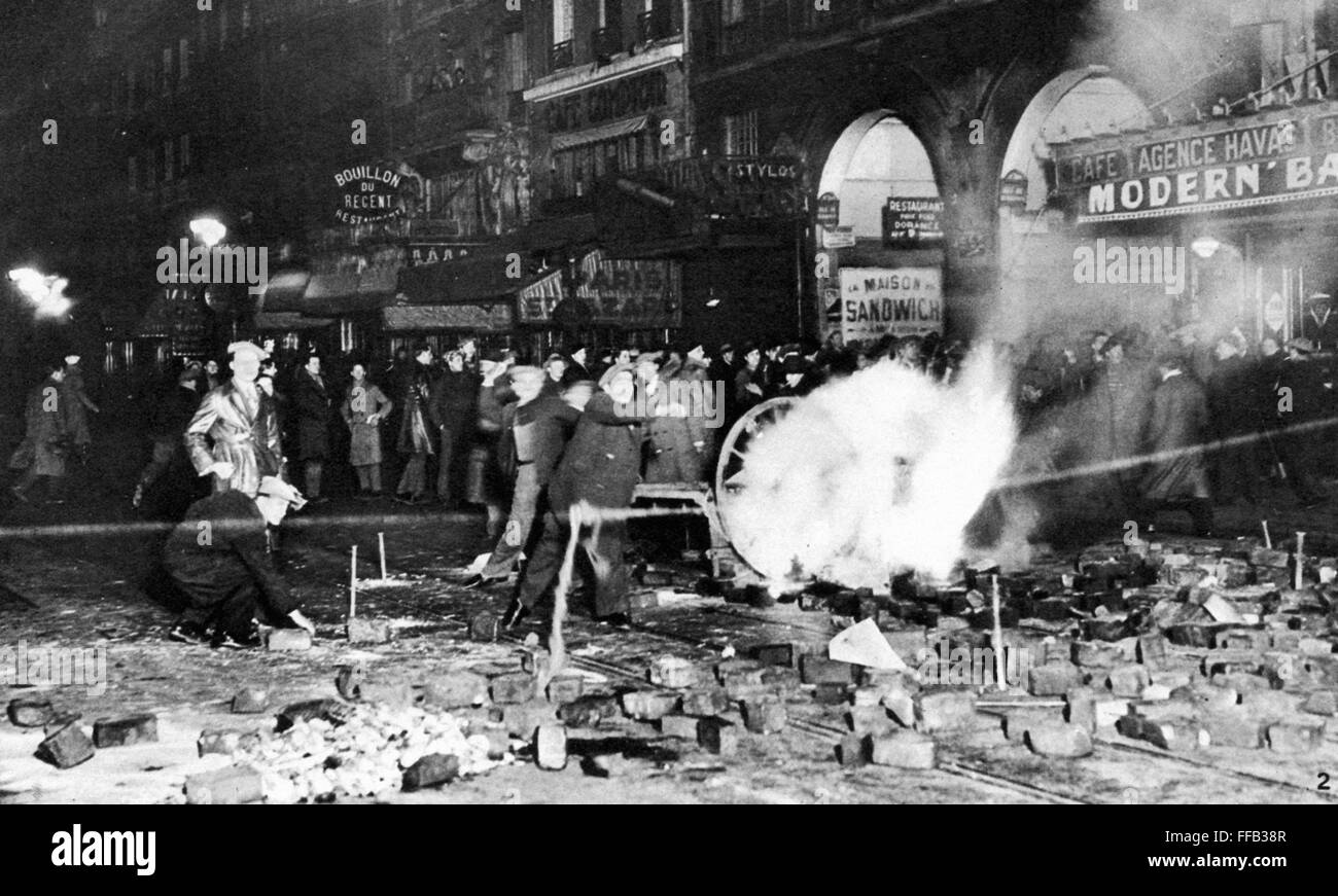 FRANCE: PARIS RIOTS, 1934. /nA rioter throws a missile from a burning street barricade in Paris during the Stavisky riots of 6-8 February 1934. Stock Photo