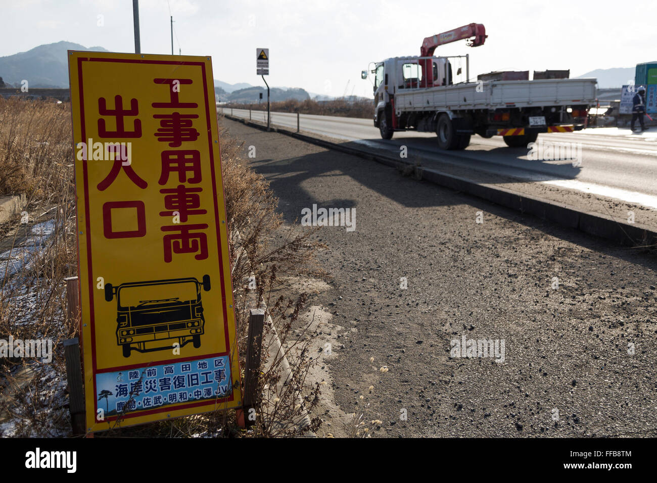 A truck runs past a construction sign next to the highway in Rikuzentakata on February 10, 2016, Iwate Prefecture, Japan. Rikuzentakahata was one of the worst hit towns by the 2011 Tohoku Earthquake and Tsunami with more than 1,700 residents losing their lives. 5 years on the effort to rebuild continues. © Rodrigo Reyes Marin/AFLO/Alamy Live News Stock Photo