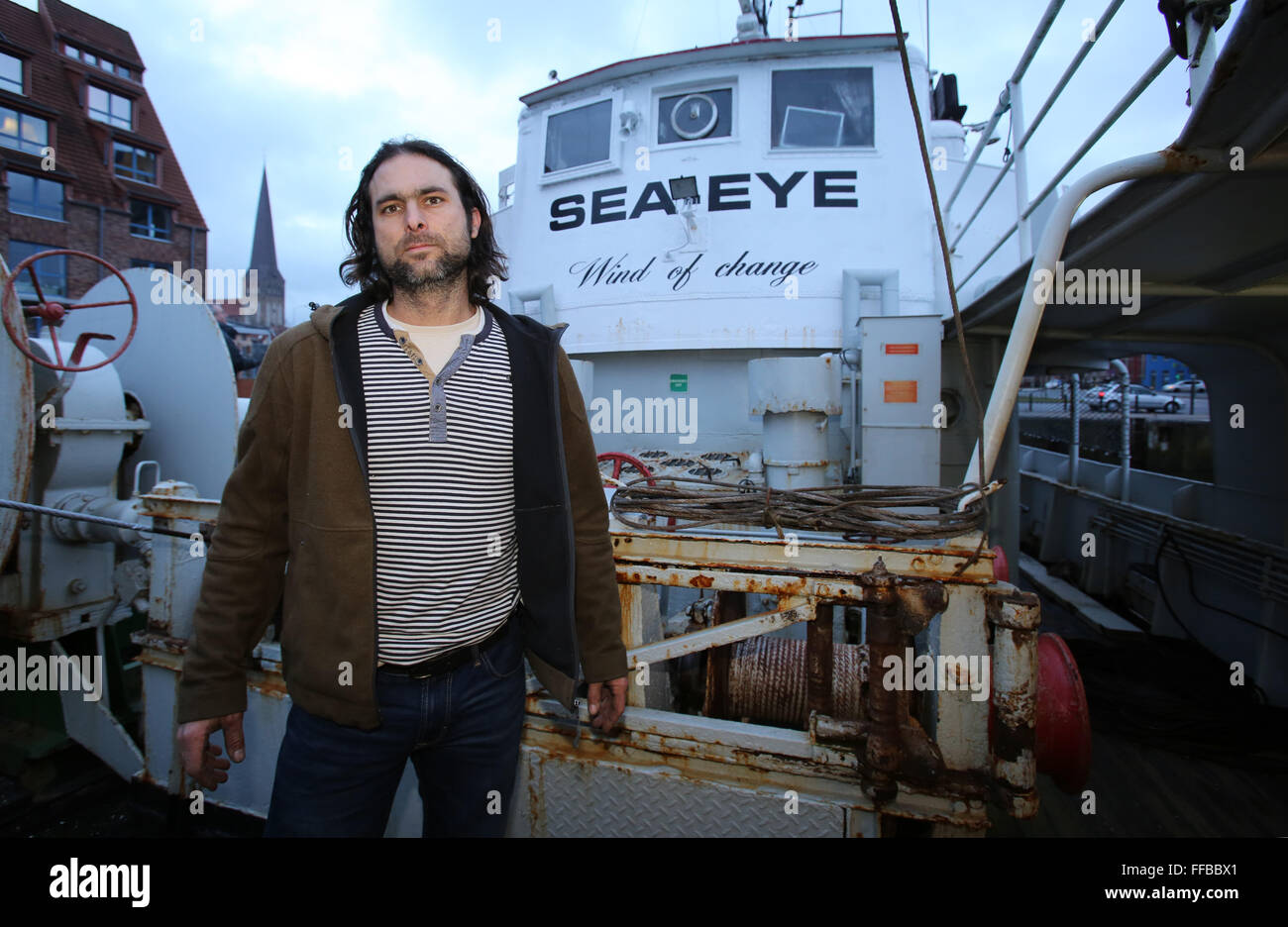 Rostock, Germany. 10th Feb, 2016. Michael Buschheuer from Regensburg stands at the pier next to his converted fishing trawler in Rostock, Germany, 10 February 2016. Five months ago Buschheuer has founded the initiative 'Sea Eye' to rescue refugees in distress in the Mediterranean. Buschheuer is planing to leave Rostock for the Mediaterranean on 20 February 2016. PHOTO: BERND WUESTNECK/dpa/Alamy Live News Stock Photo