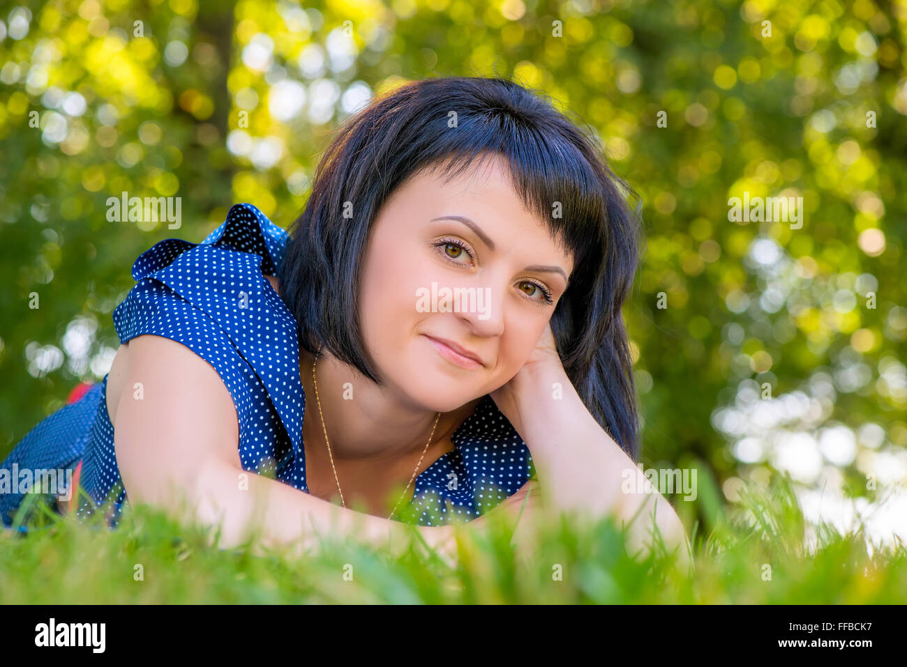 a beautiful young woman lying on the green grass in the park Stock ...