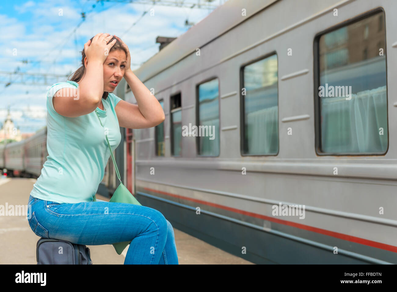 emotional woman looks at the departing train on which she was late Stock Photo
