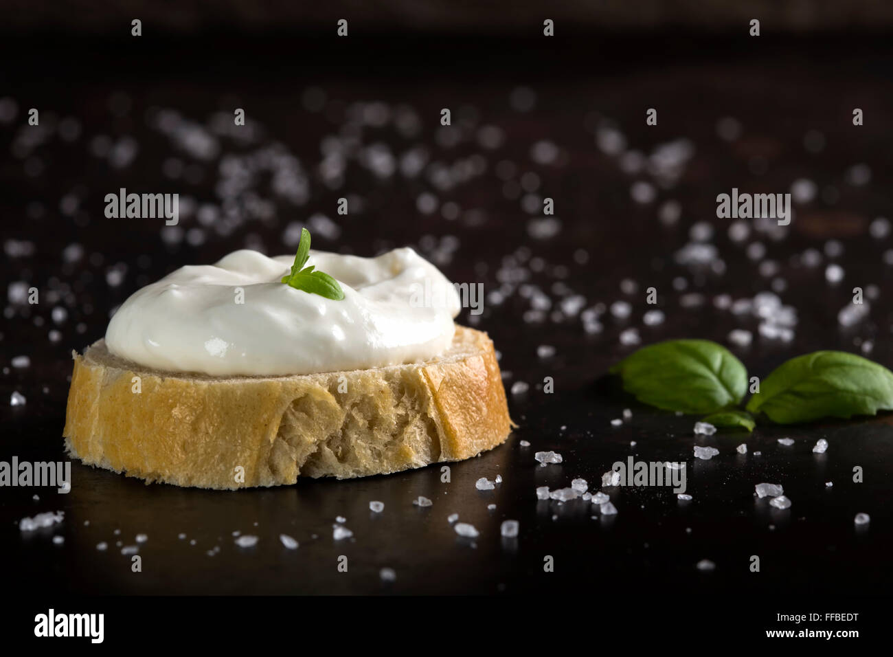 Cream cheese with herbs and seasoning on a slice of fresh rye bread Stock Photo