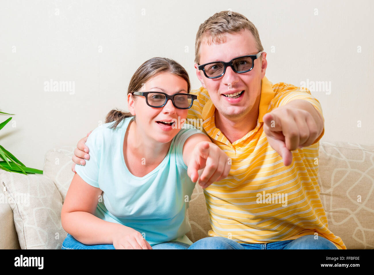 portrait of young couples looking TV in 3D glasses in the living room Stock Photo