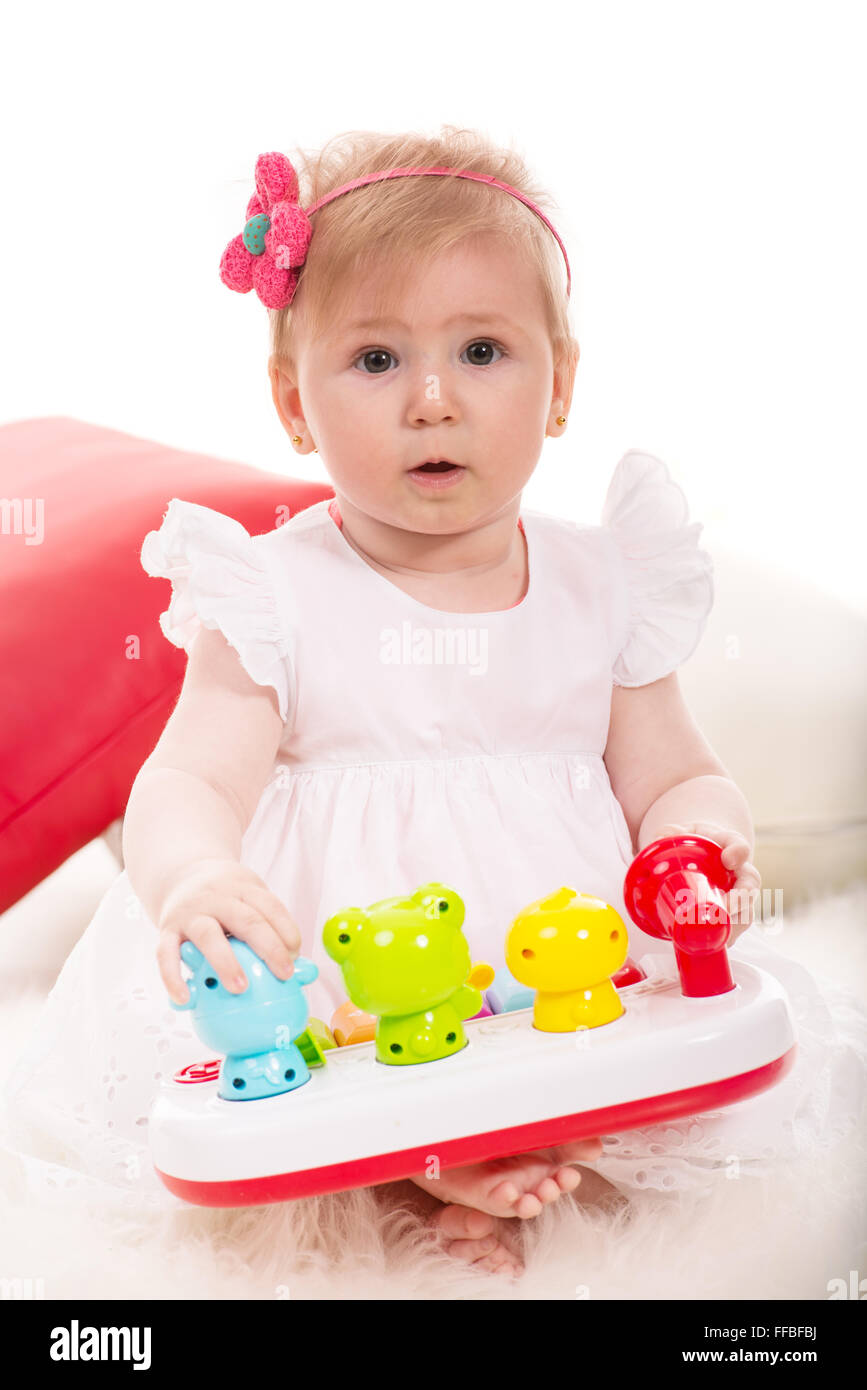Cute baby girl playing with toys  and sitting on blanket Stock Photo