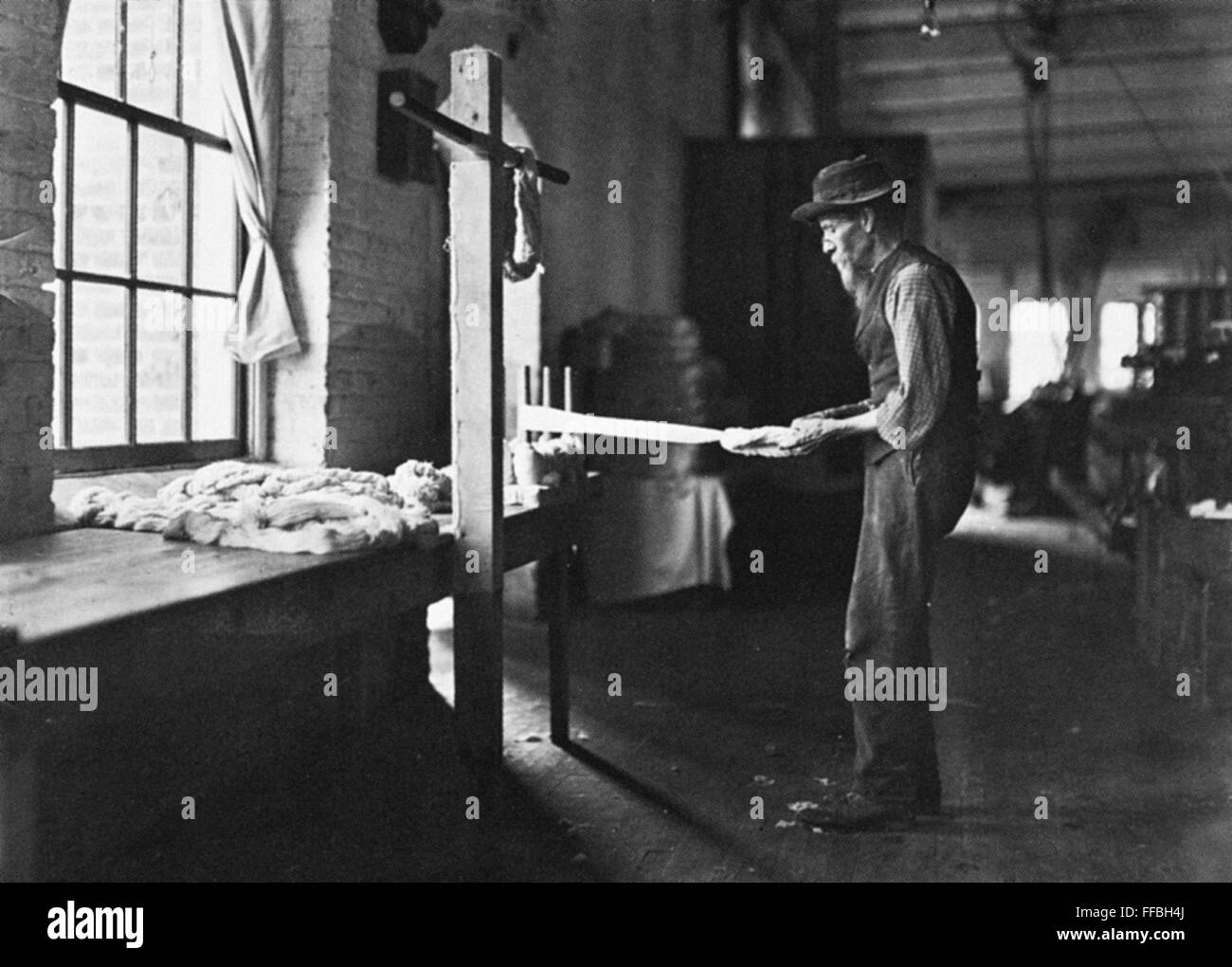 TEXTILE MILL WORKER, 1908. /nOld man inspecting yarn. Rhodes