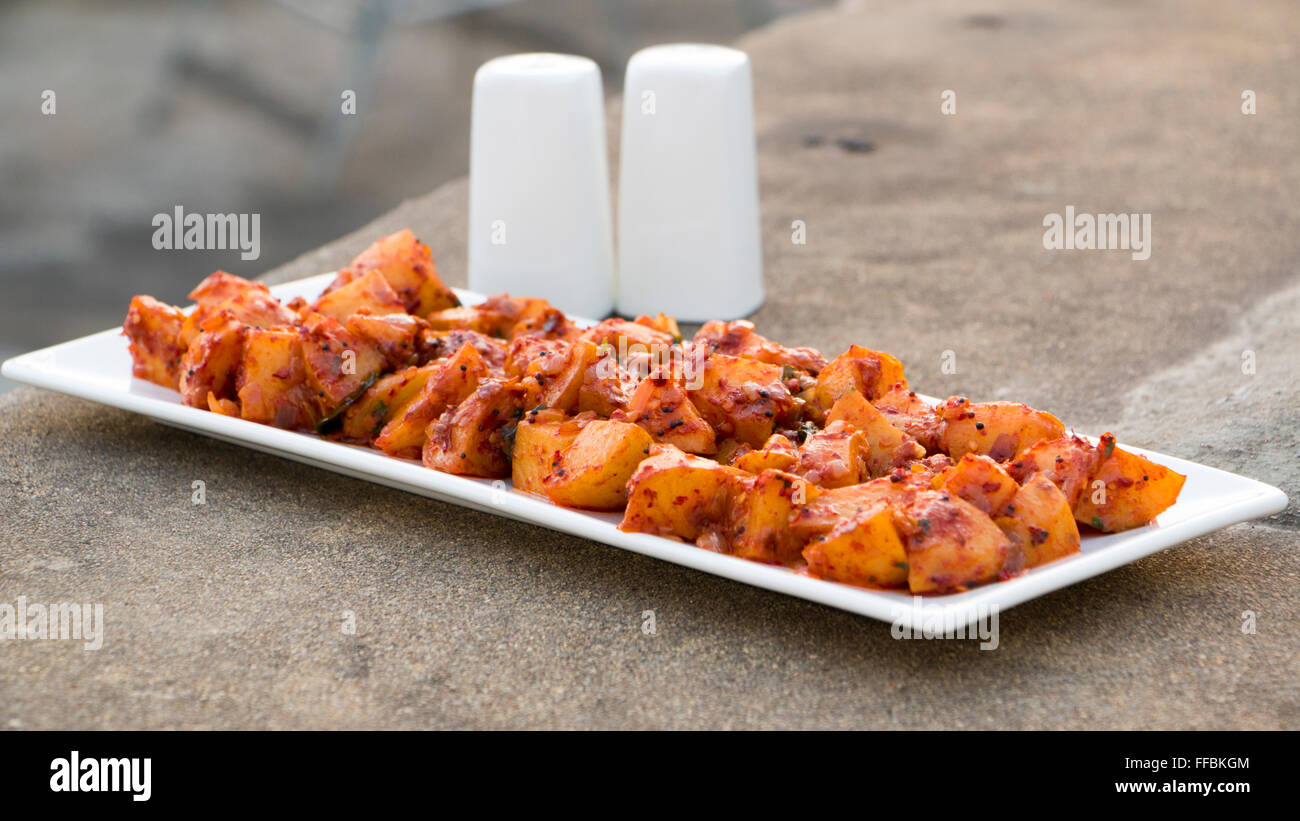 Batata saung is a konkani dish in which potatoes are cooked with spicy chilli and tamarind sauce. This can be eaten with rotis o Stock Photo