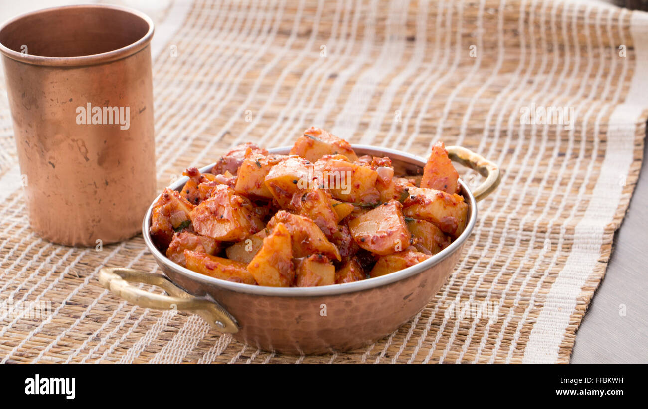 Batata saung is a konkani dish in which potatoes are cooked with spicy chilli and tamarind sauce. This can be eaten with rotis o Stock Photo
