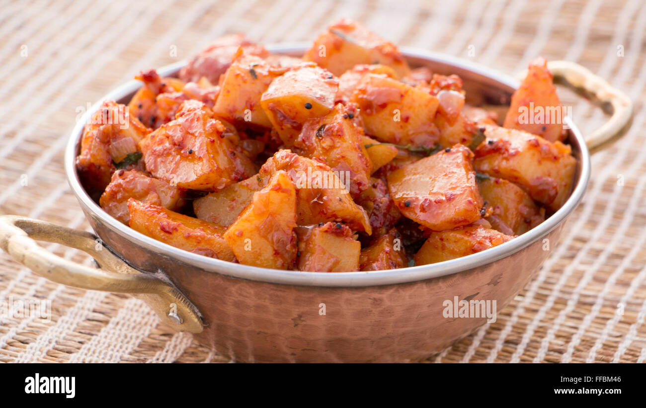 Batata saung is a konkani dish in which potatoes are cooked with spicy chilli and tamarind sauce. This can be eaten with rotis o Stock Photo