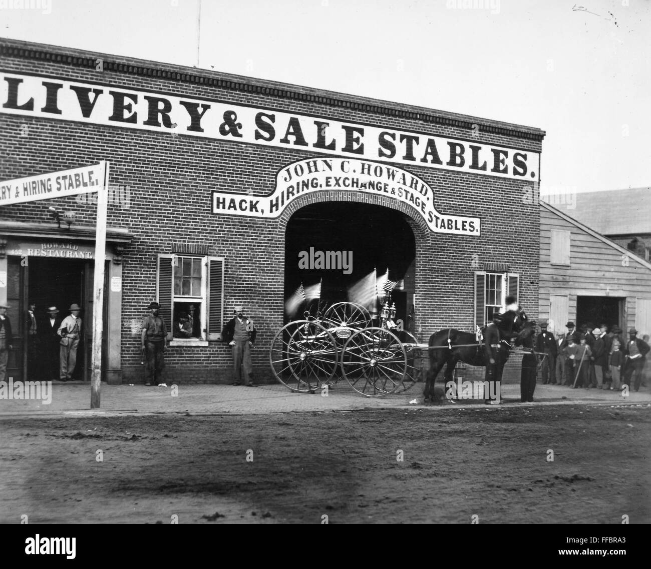WASHINGTON: STABLES, 1865. /nJohn C. Howard's livery stable and saloon on G Street in Washington, D.C., where John H. Surratt, a conspirator in the Abraham Lincoln assassination, kept horses before leaving town on 1 April 1865. At right is a horse drawn h Stock Photo