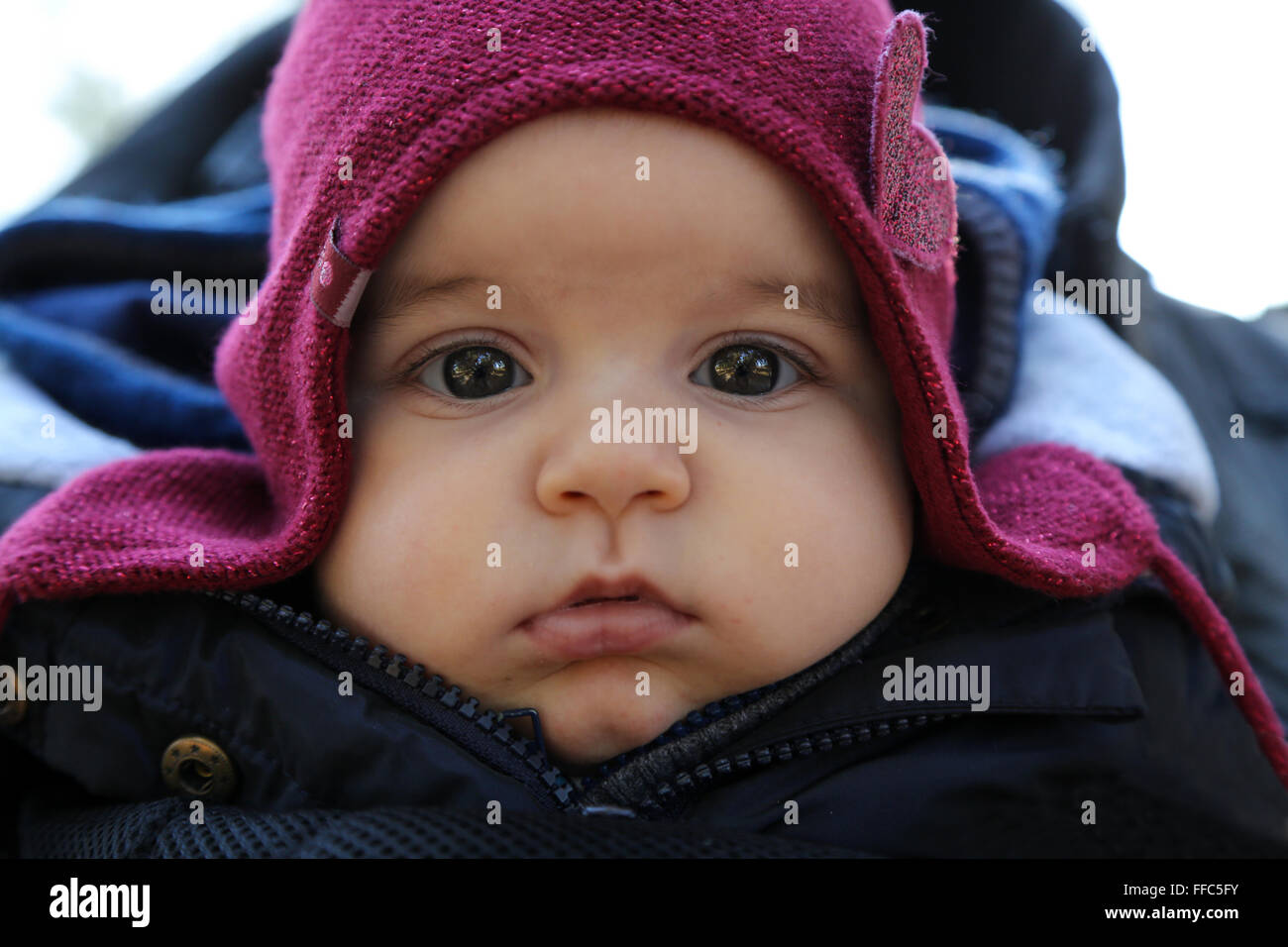 cute baby's portrait with chubby cheek's while wearing winter clothes Stock Photo