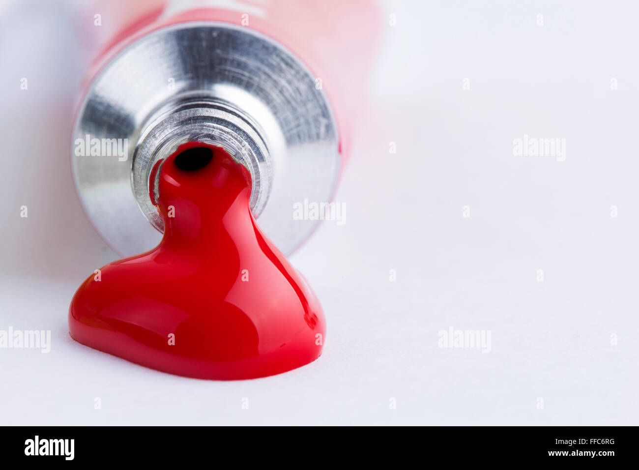 Red paint spill from tempera on white background Stock Photo