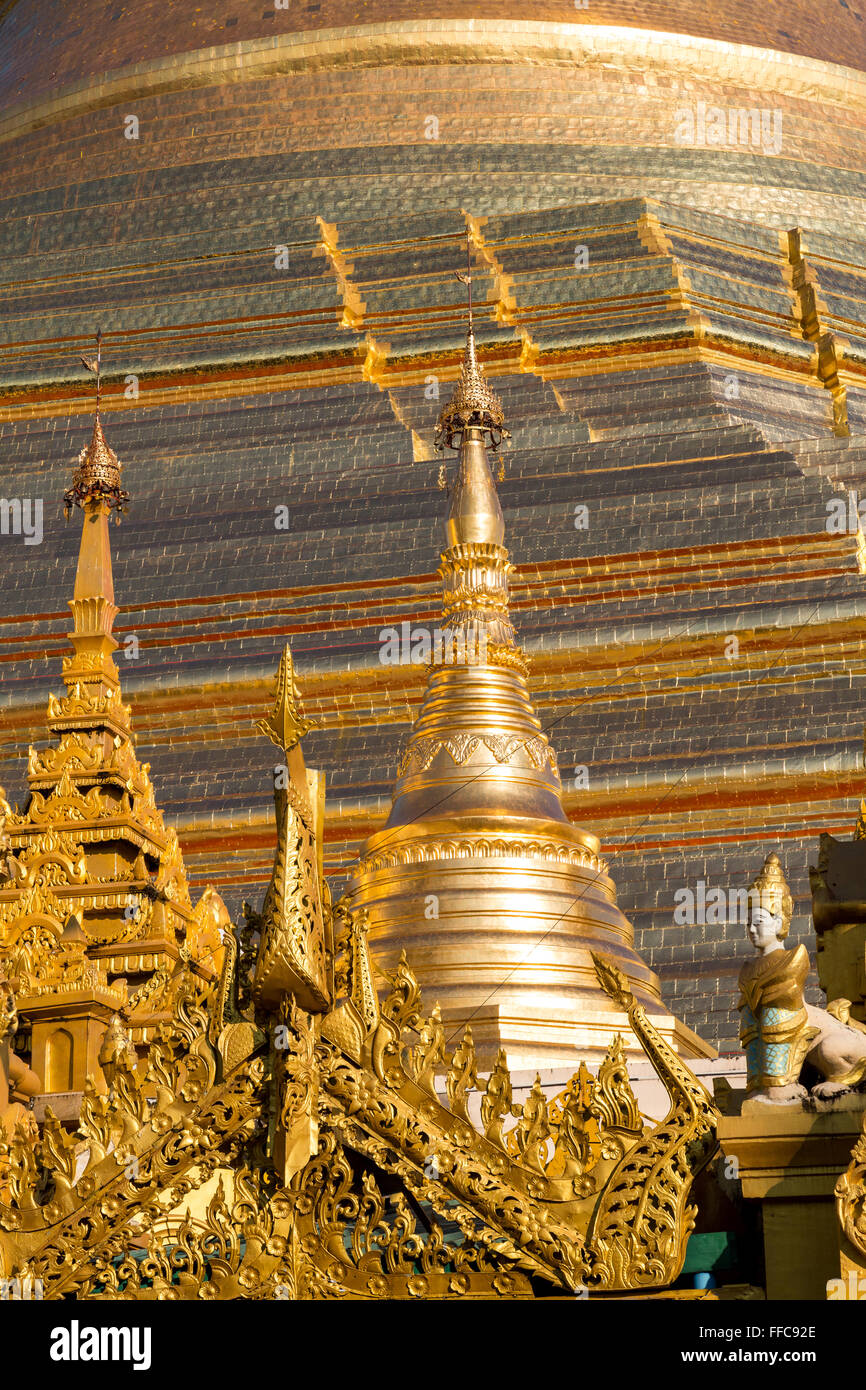 The beautiful multiple gold layers of the Shwedagon pagoda glisten in the early morning sun in Yangon Stock Photo
