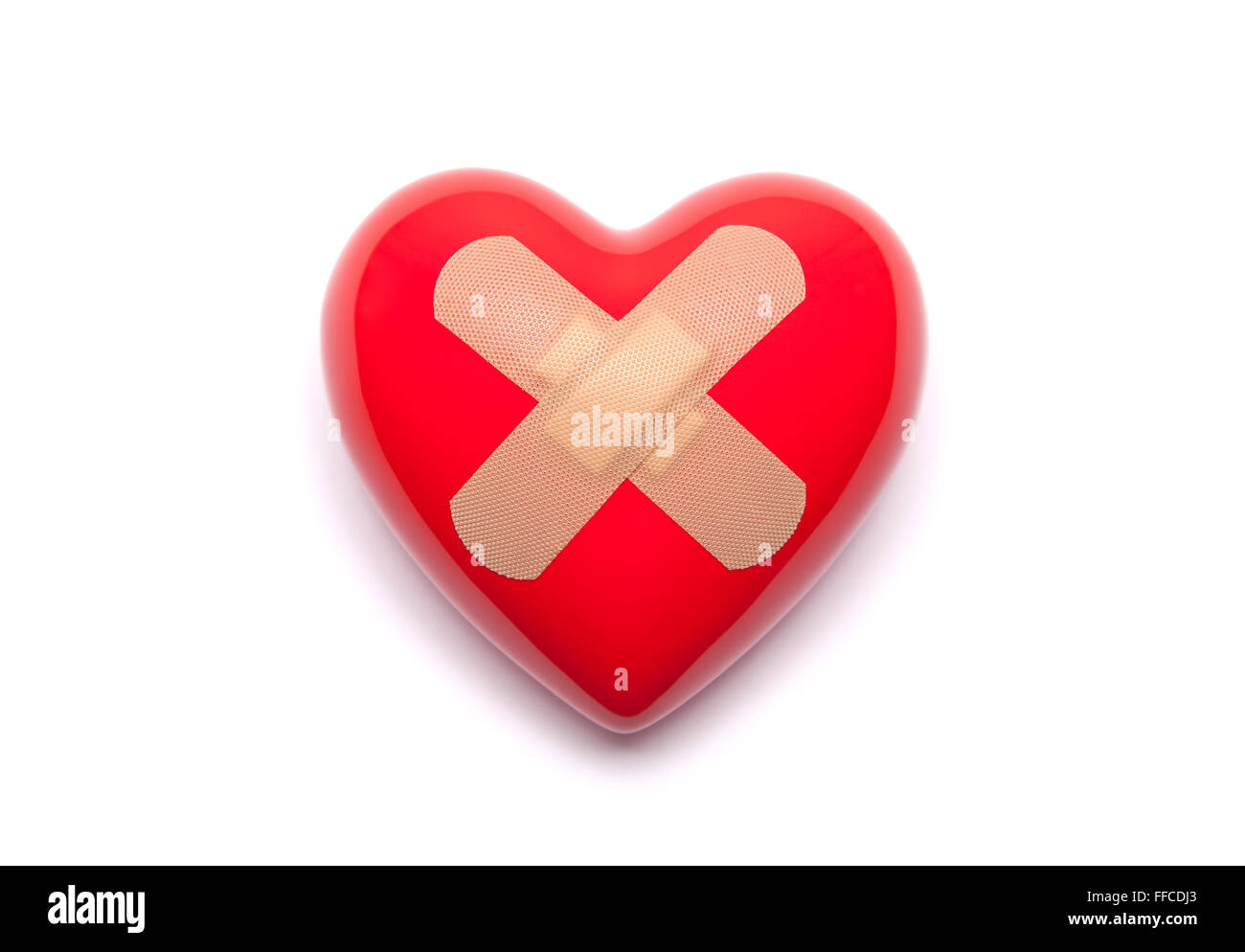 Red heart with adhesive plaster on white background Stock Photo