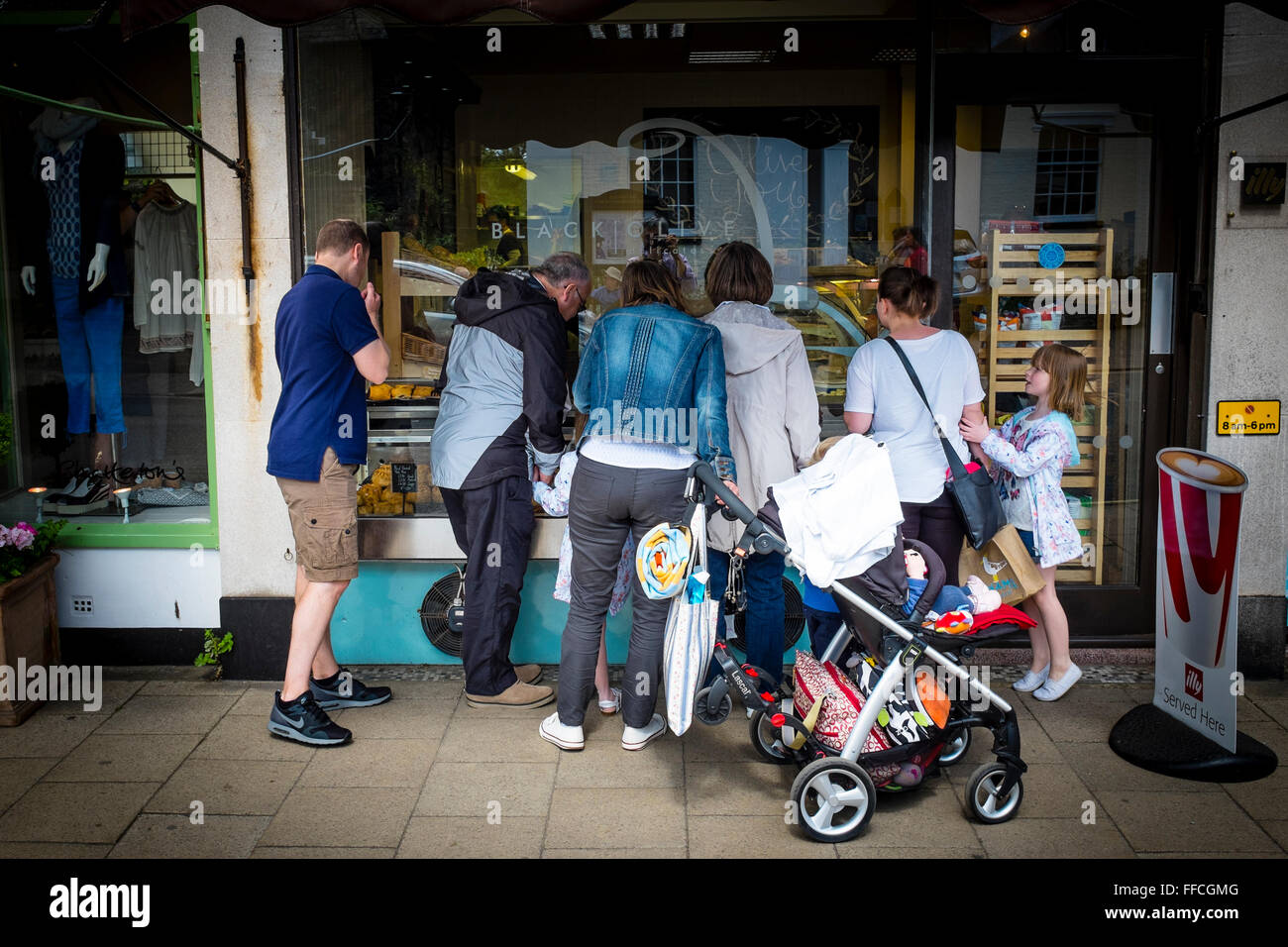 Group of people looking through the window of a shop, Southwold, Suffolk, UK Stock Photo