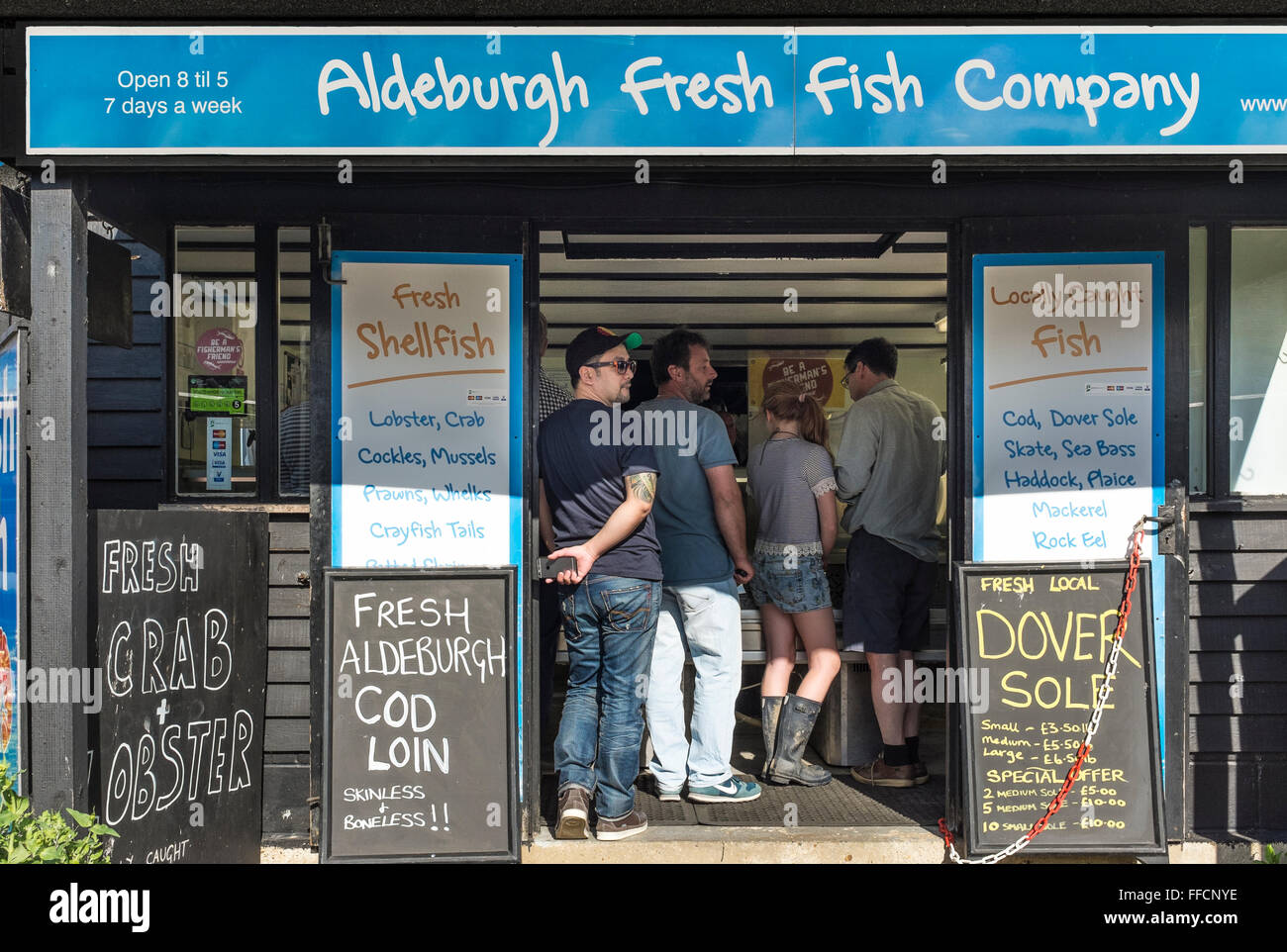 people queuing to buy fresh fish at fishmonger, Aldeburgh, Suffolk, UK