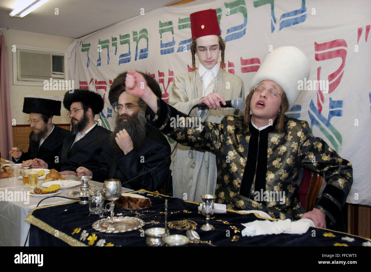 During the Jewish festival of Purim a group of Orthodox Jewish boys from the Viznitz Yeshiva (school) in fancy dress visit local businessmen to collect money for their school. At the end of the day they return to their school and have a celebration feast, the Purim Rabbi performs a song to his class during the meal. Large amounts of alcohol are consumed during the festival. Stock Photo