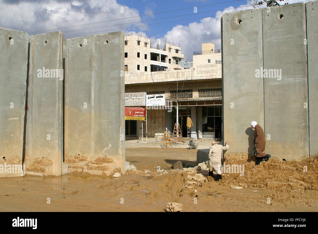 Palestinian women pass through a gap in the controversial Wall between Israel and Palestine rather than going through the Qalandiya checkpoint. Stock Photo