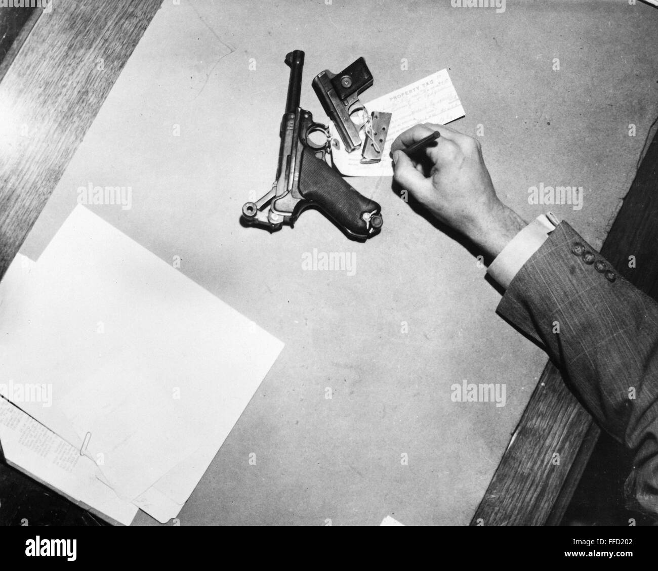 GUNS LEFT AT HOLD UP, 1950./nA German Luger and an automatic pistol