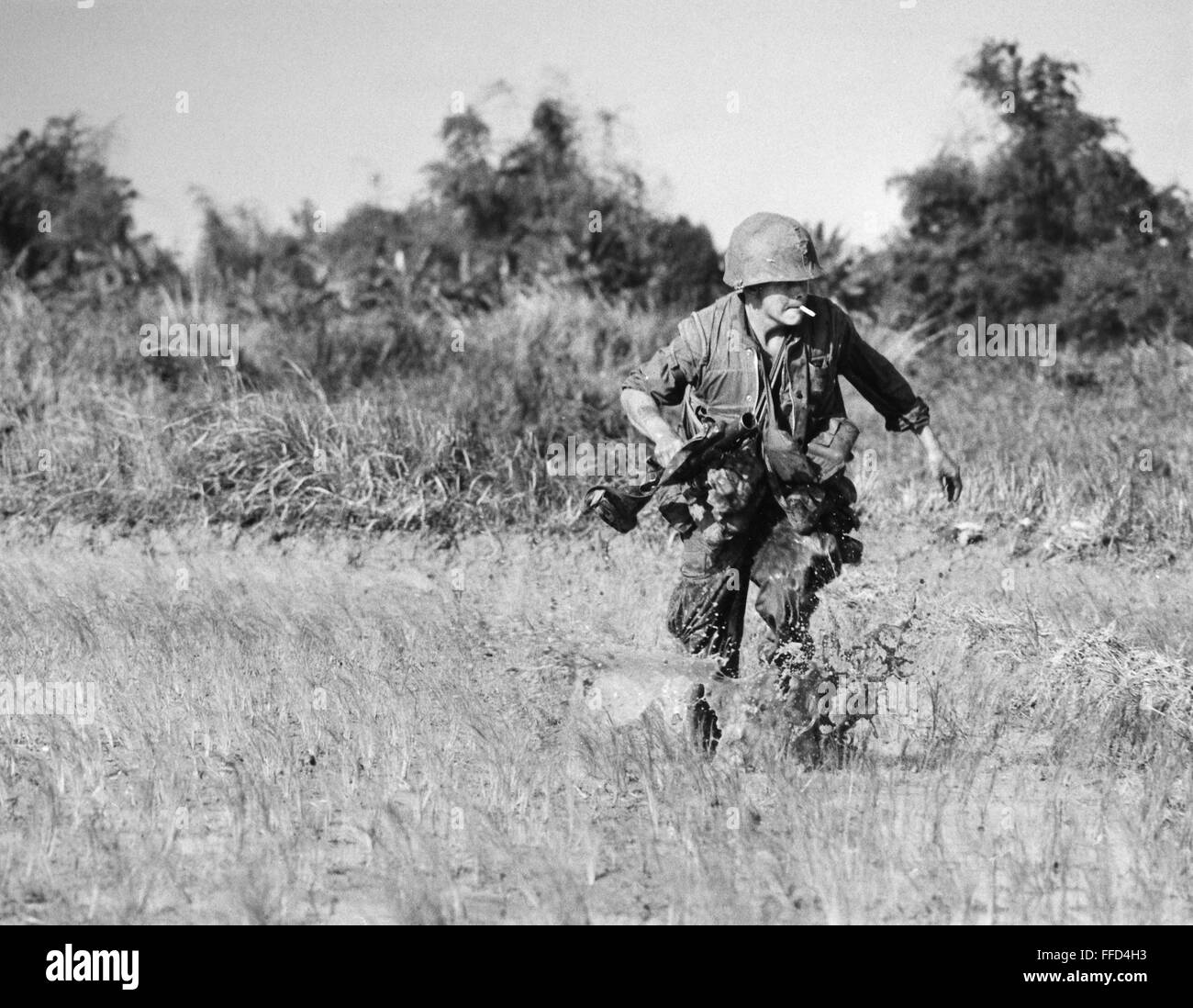 VIETNAM WAR: RIFLEMAN./nU.S. Marine rifleman pinned down in a rice paddy near Hoi An, South Vietnam, December 1967. Stock Photo