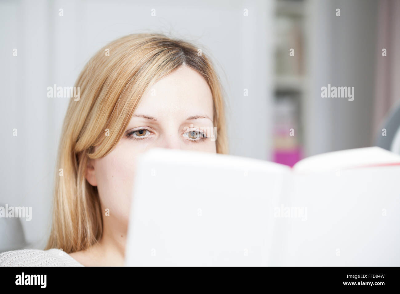 woman is reading a book at home Stock Photo