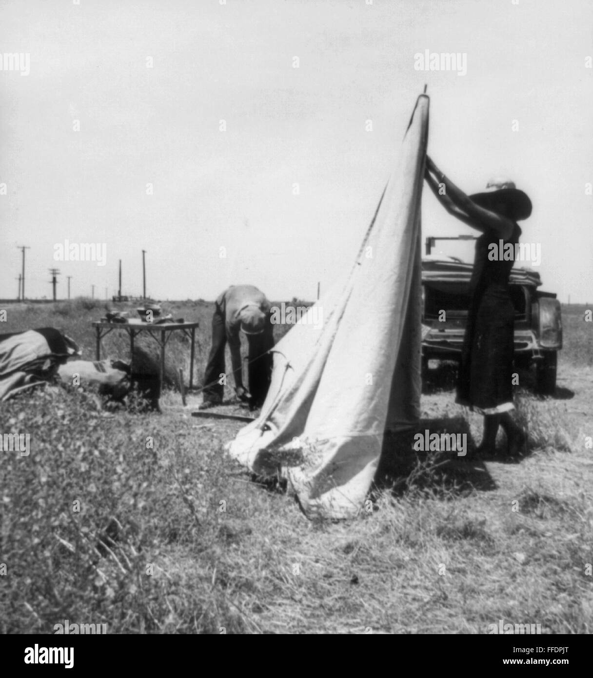 MIGRANT FARMERS, 1937. /nMigrant potato pickers pitching their tent, near Shafter, California. Photograph by Dorothea Lange, May 1937. Stock Photo