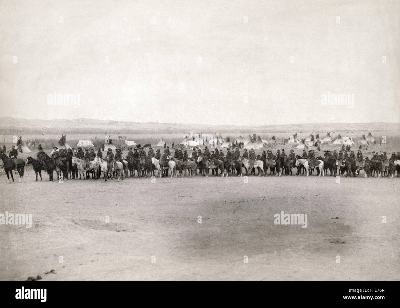 U.S. ARMY SCOUTS, 1891. /nA long row of U.S. military men and Lakota Sioux scouts on horseback in front of a tipi camp. Photographed in 1891 by John C.H. Grabill, probably on or near the Pine Ridge Reservation in South Dakota. Stock Photo