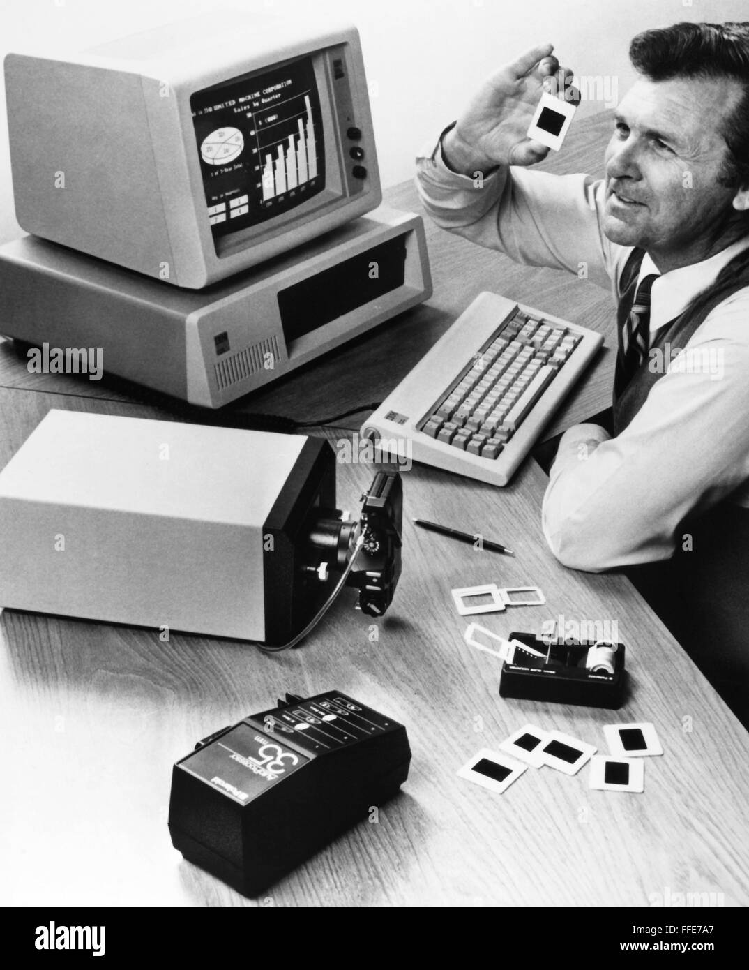 DIGITAL IMAGES, 1984. /nA computer user holds a 35-mm slide of a ...