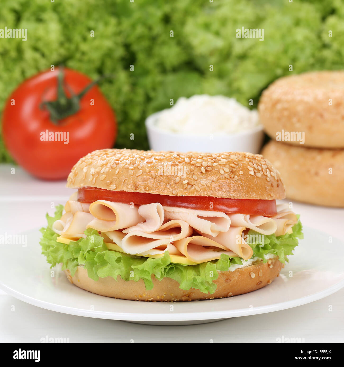 Healthy eating bagel for breakfast with ham, cream cheese, tomatoes and
