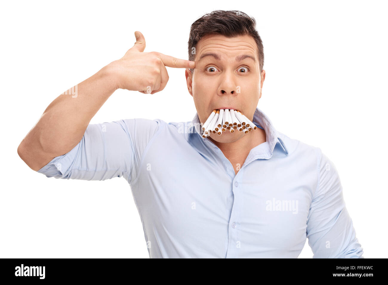 Studio shot of a man with a bunch of cigarettes in his mouth holding a hand gun against his head isolated on white background Stock Photo