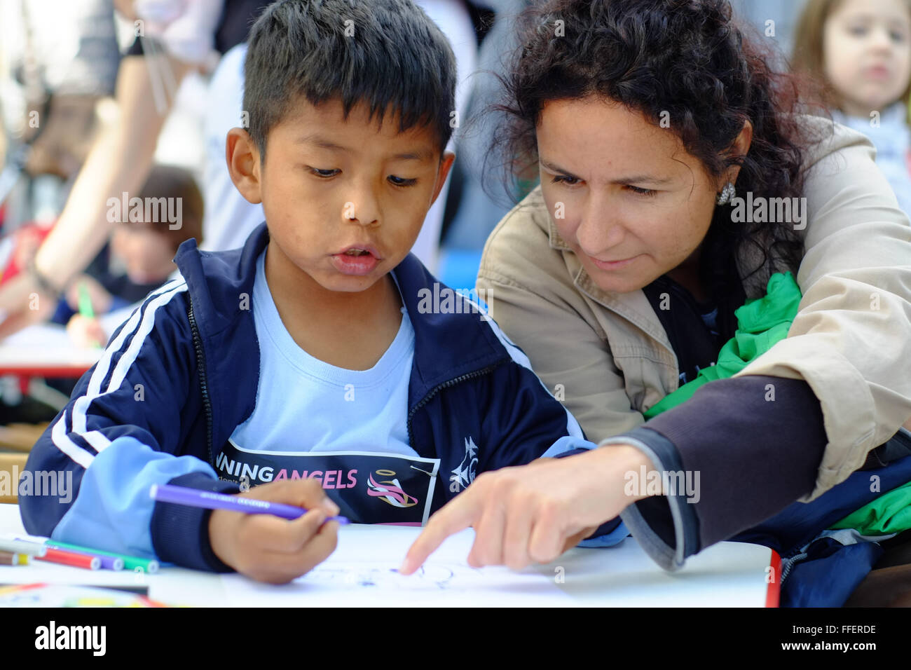 Mature caucasian woman helps her adopted latin boy filling a short marathon form Stock Photo
