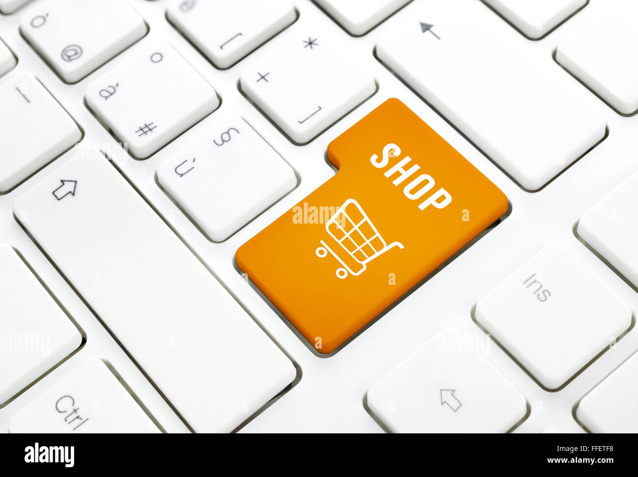 Shop business concept, Orange shopping cart button or key on white keyboard photography. Stock Photo