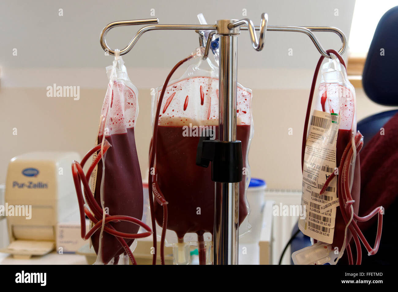 Blood plasma packs hanging from stand in a hospital room Stock Photo