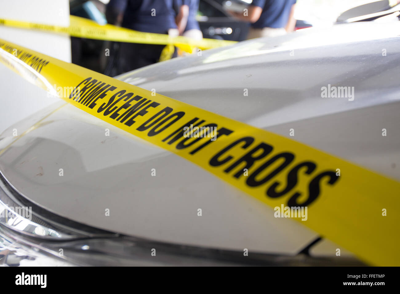 caution tape protect area of crime scene investigation and car  background in training course Stock Photo