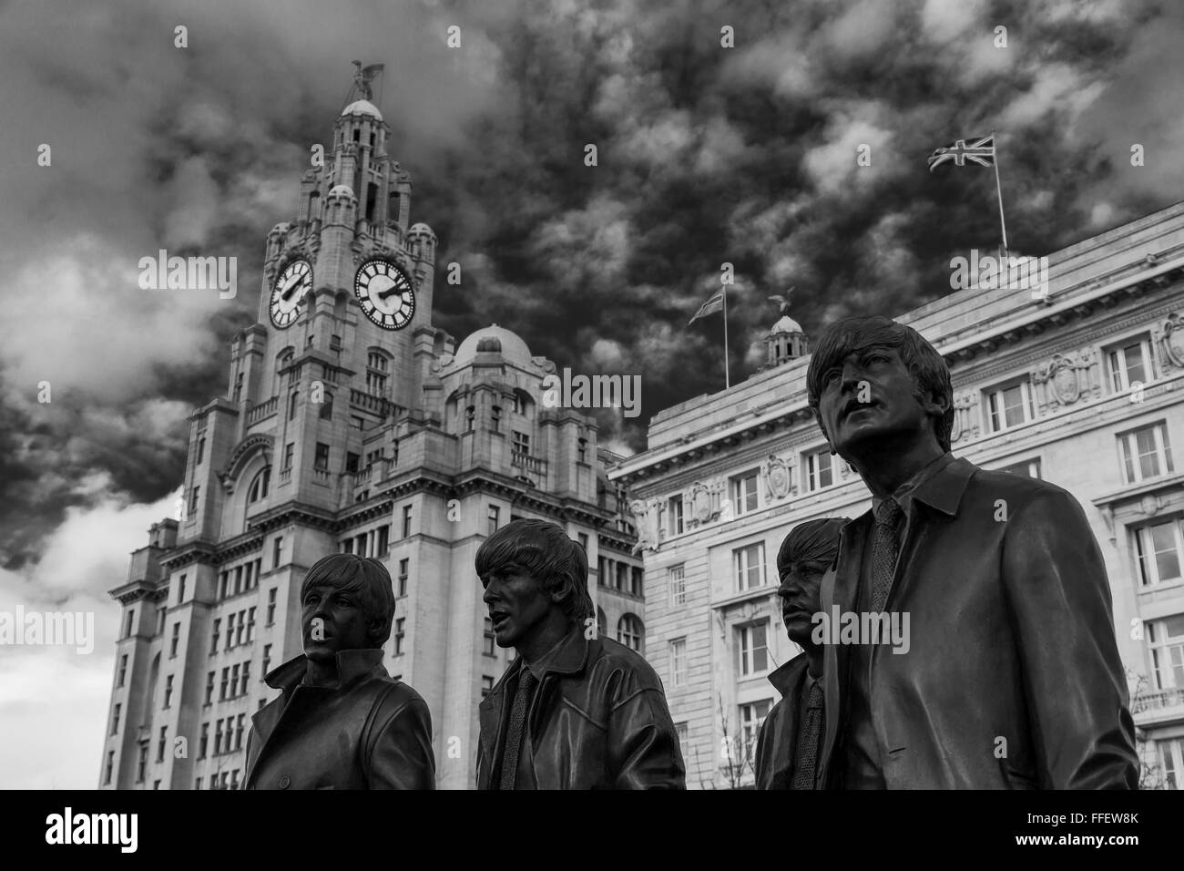 Black statues of John Lennon, Paul McCartney, Ringo Starr, George Harrison seen in front of the Royal Liver & Cunard Buildings. Stock Photo