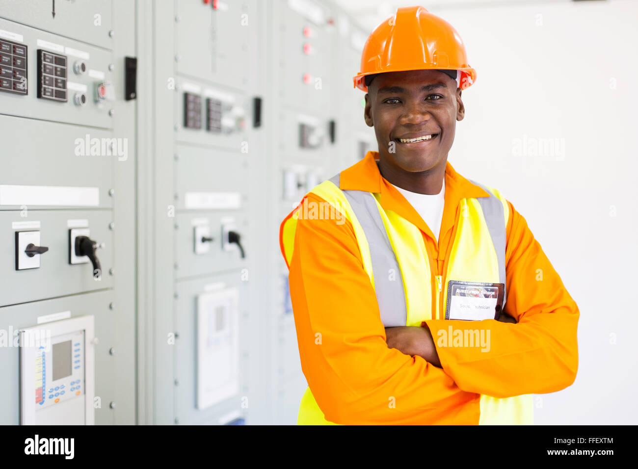 cheerful African industrial technician in substation control room Stock Photo