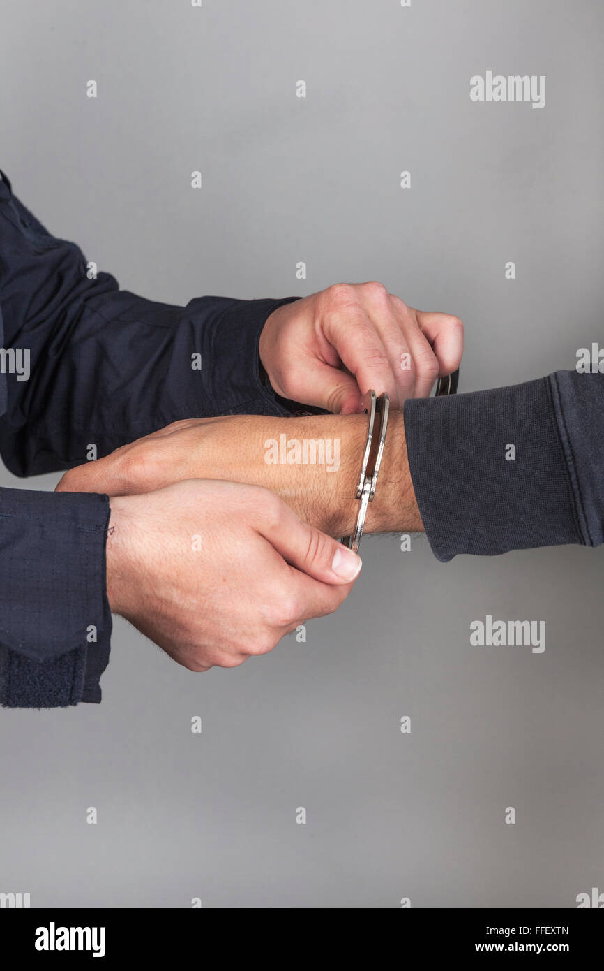 police officer puts handcuffs Stock Photo Alamy
