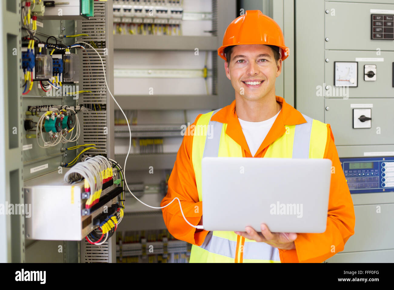 portrait of professional industrial technician in front of machinery control panel Stock Photo