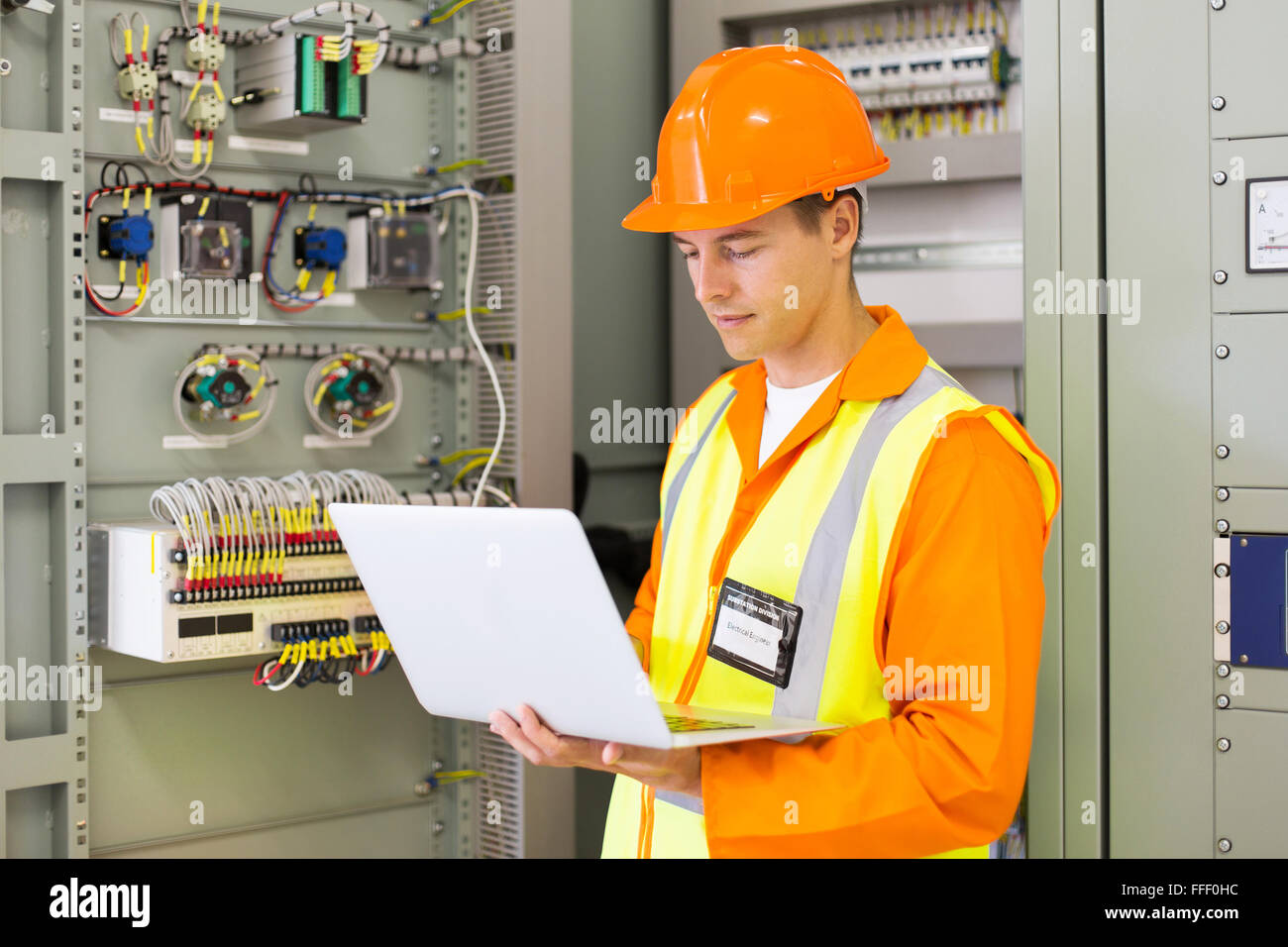 experienced industrial engineer using laptop computer in machine control room Stock Photo