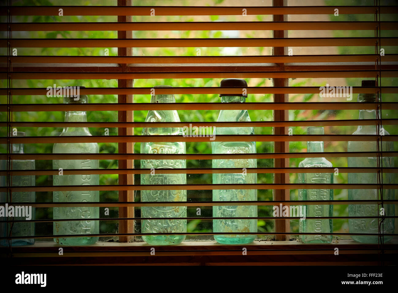 Antique green glass bottles displayed in window Stock Photo