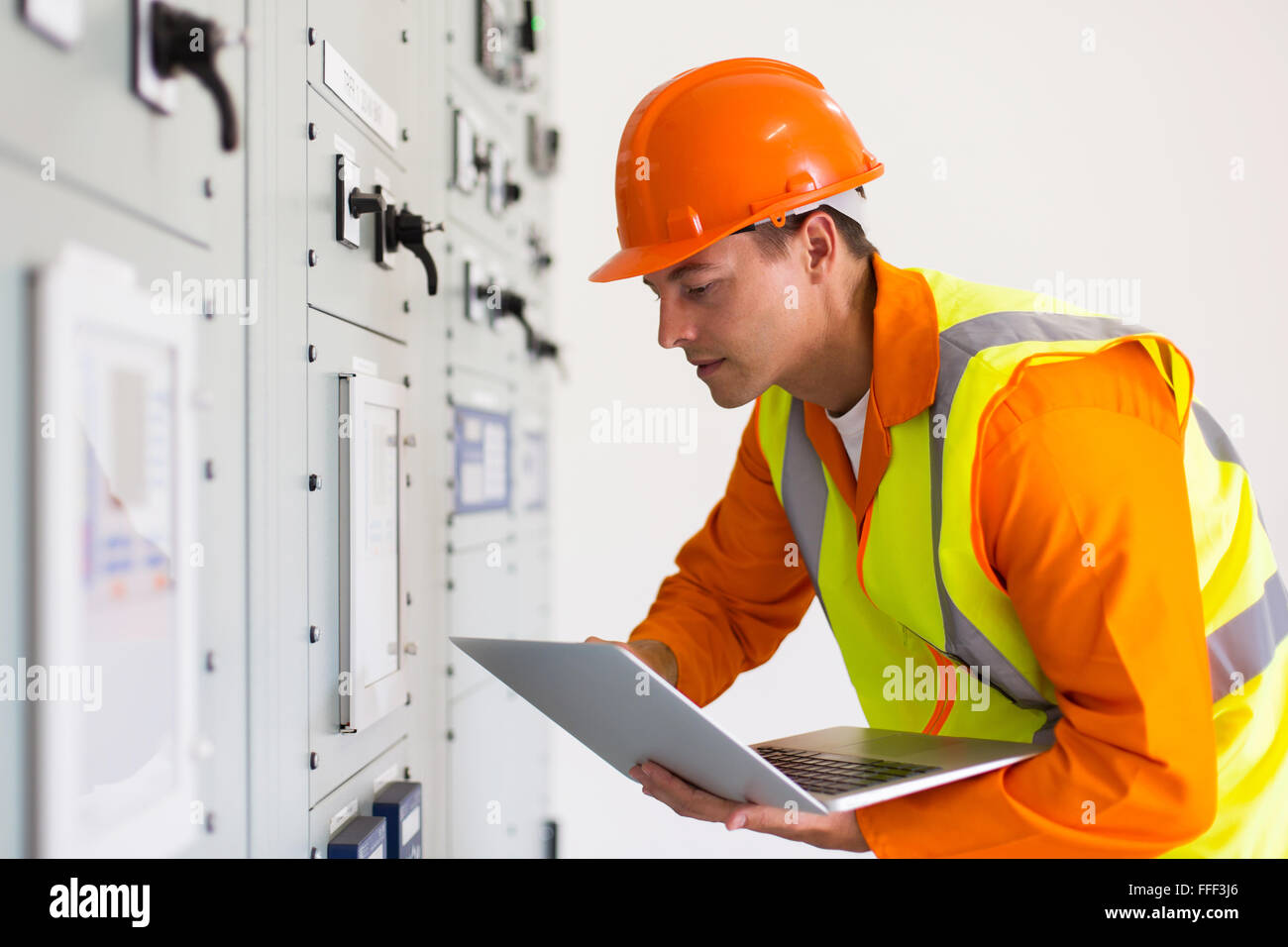 male industrial engineer using laptop in control room Stock Photo