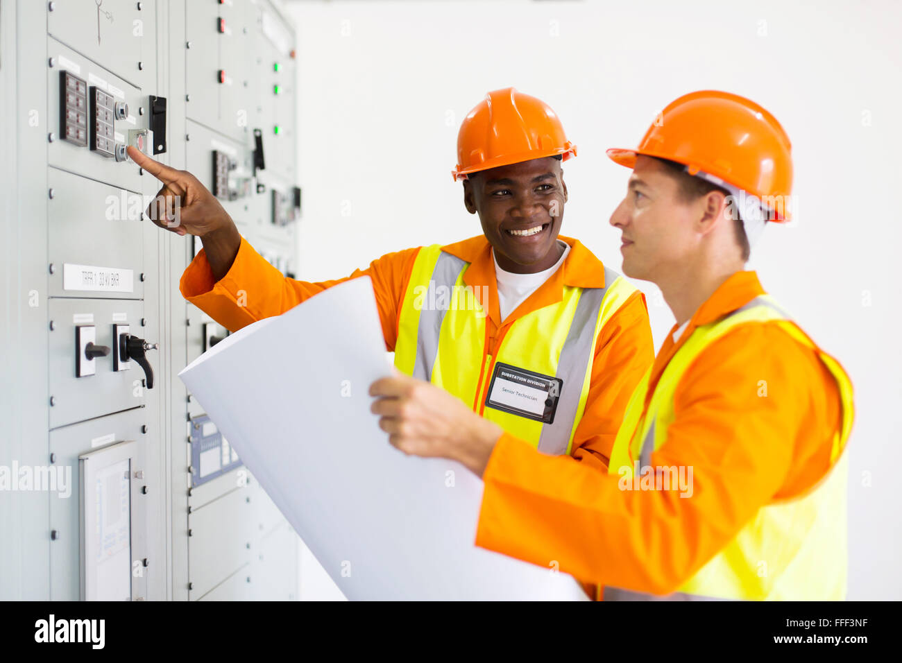 two industrial technicians working in control room Stock Photo