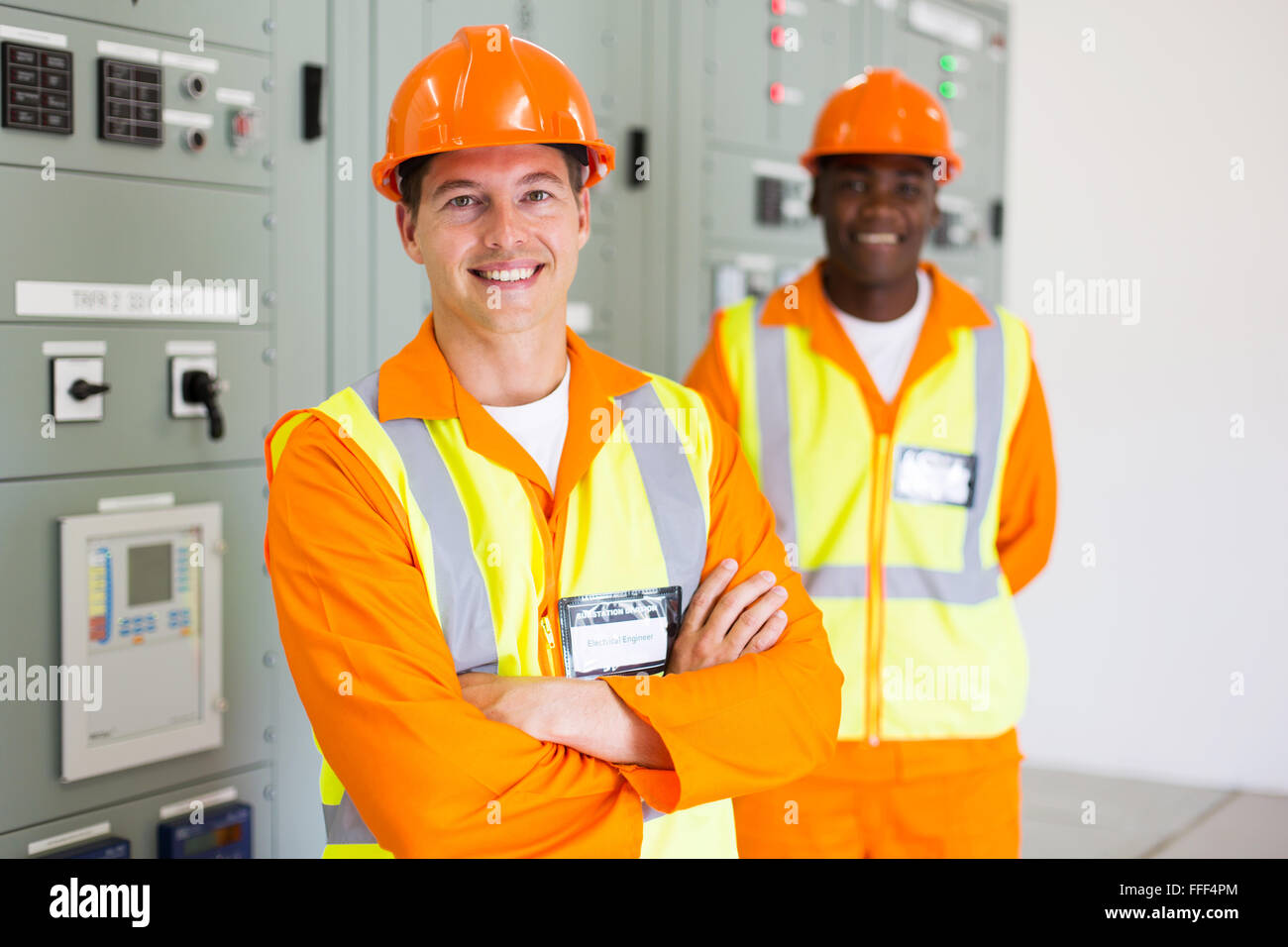 professional industrial electrician with colleague on background Stock Photo
