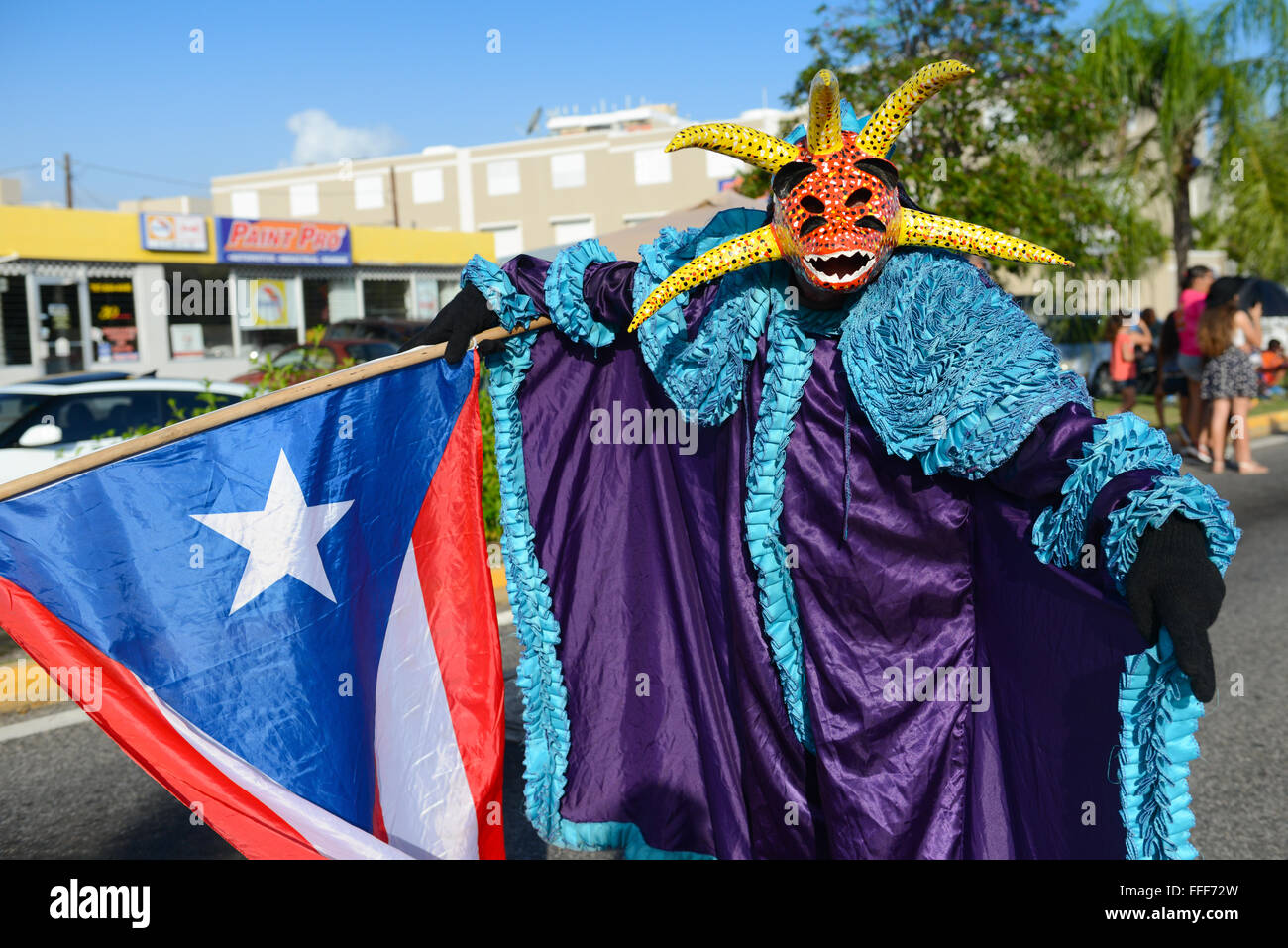Traditional cultural figure VEJIGANTE posing with flag during the carnival in Ponce. Puerto Rico. US territory. February 2016 Stock Photo