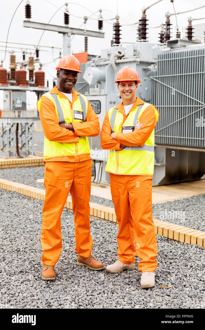 happy industrial engineers with arms crossed in substation Stock Photo