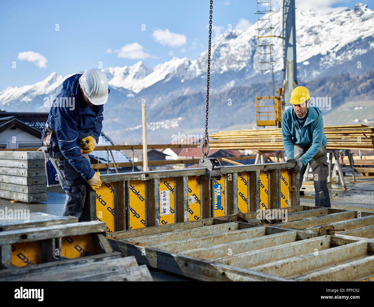 Construction workers lifting shuttering wall with crane, preparing framed formwork, Innsbruck Land, Tyrol, Austria Stock Photo