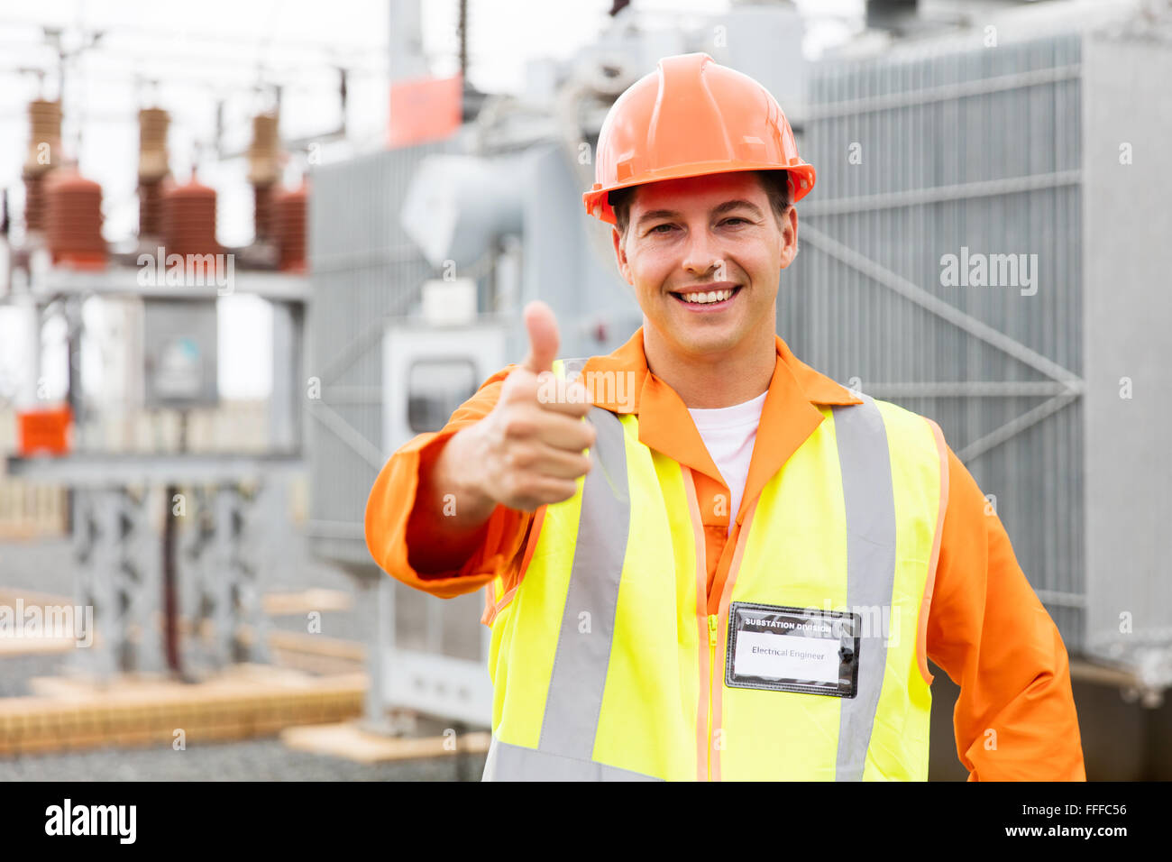 happy male electrician with thumb up at electric substation Stock Photo