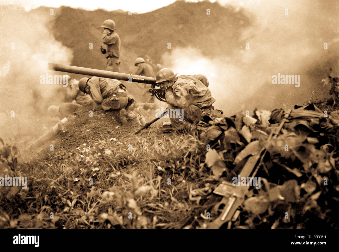 Pfc. Roman Prauty, a gunner with 31st RCT (crouching foreground), with the assistance of his gun crew, fires a 75mm recoilless rifle, near Oetlook-tong, Korea, in support of infantry units directly across the valley.  June 9, 1951. Stock Photo
