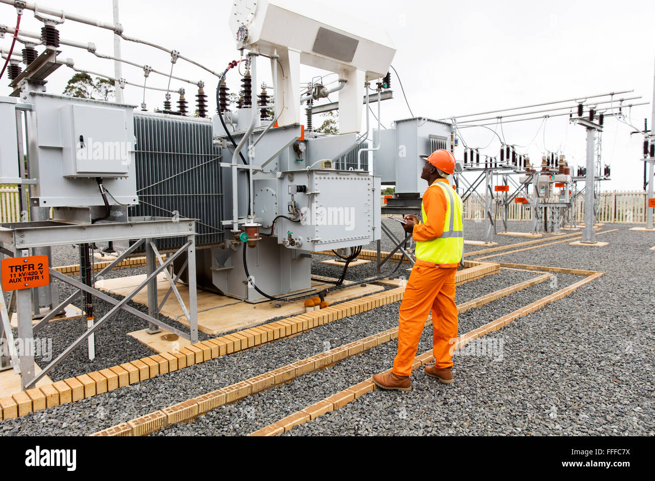 professional African electrician working in electrical substation Stock Photo