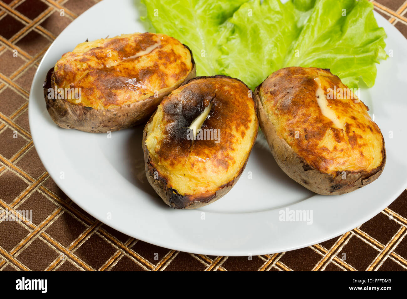 baked potatoes whole in their skins Stock Photo