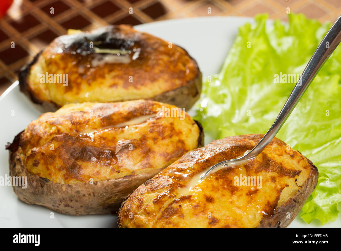 baked potatoes whole in their skins Stock Photo